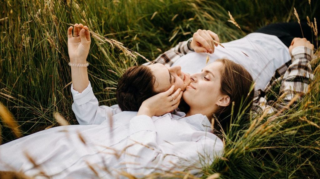 couple lying on field together opposite each other