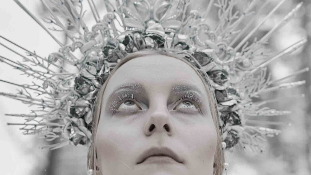 woman with a silver crown and flushed cheeks in a snowy scene