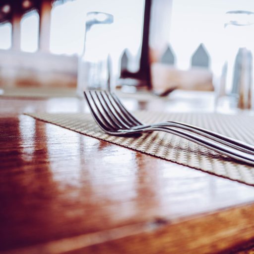 two stainless steel forks on top of place mat