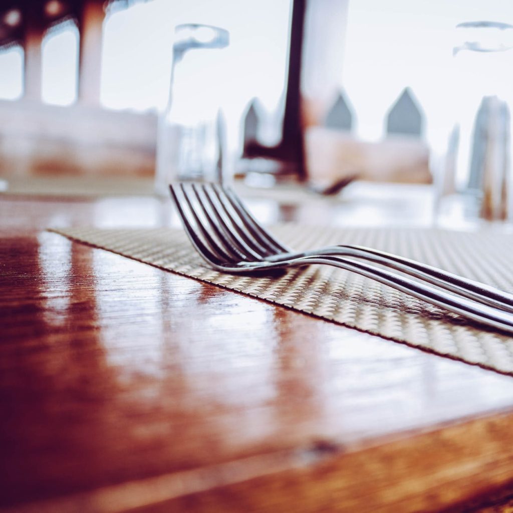 two stainless steel forks on top of place mat