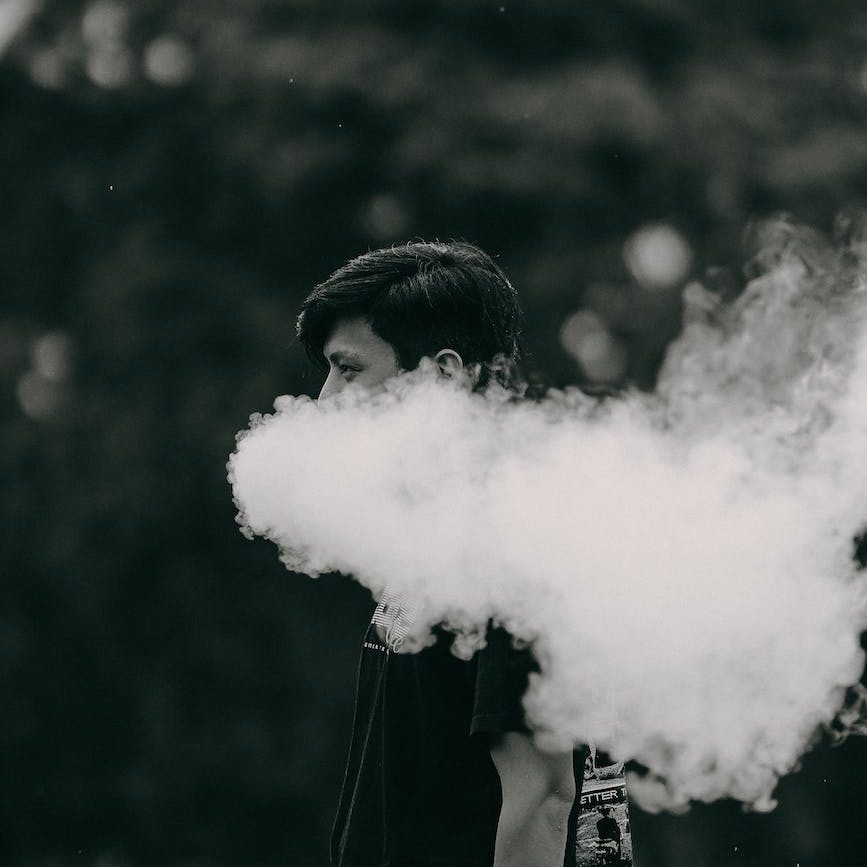 grayscale photo of a man smoking