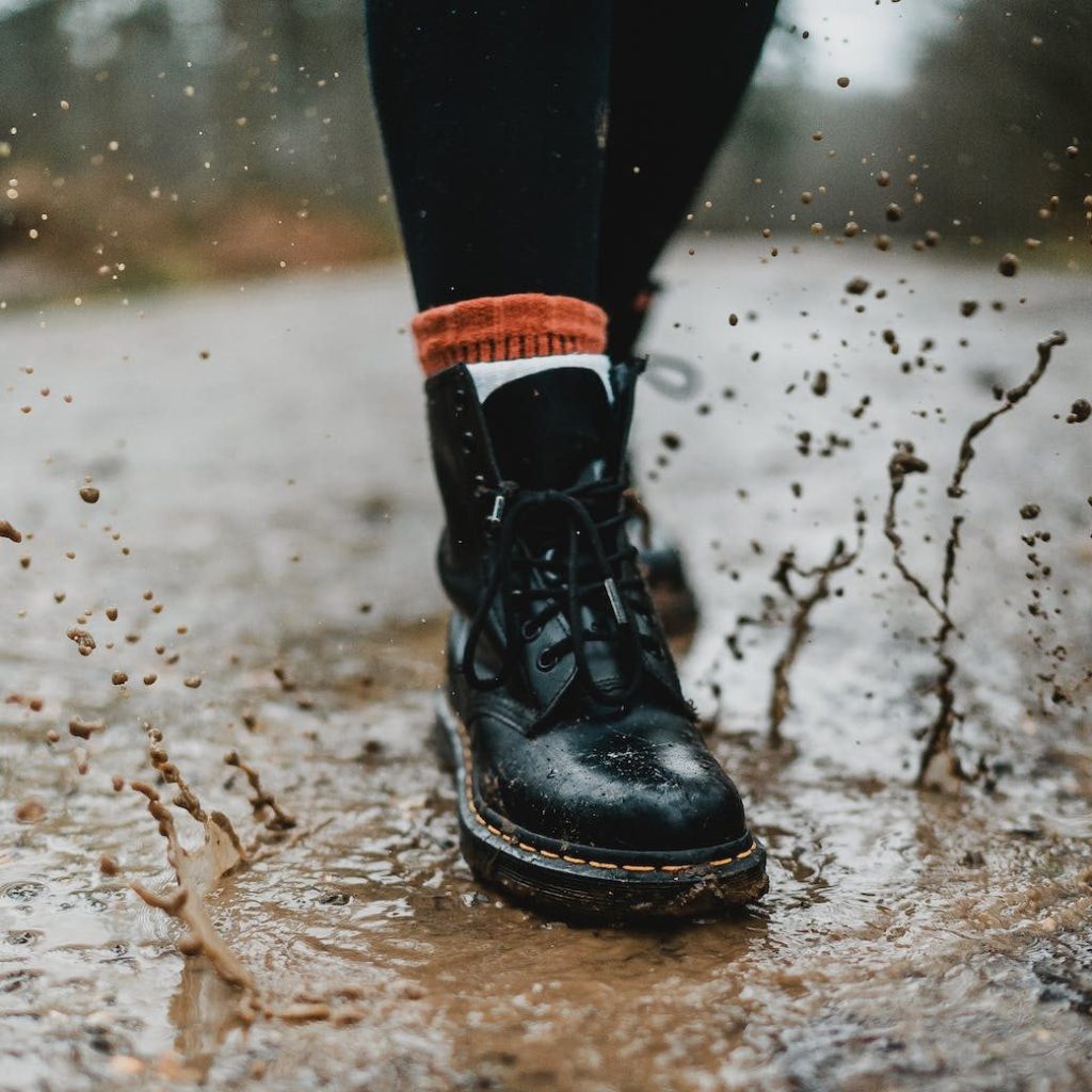 person wearing black leather work boots